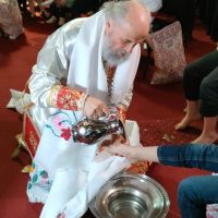 Arhiepiscop care spală picioarele copiilor