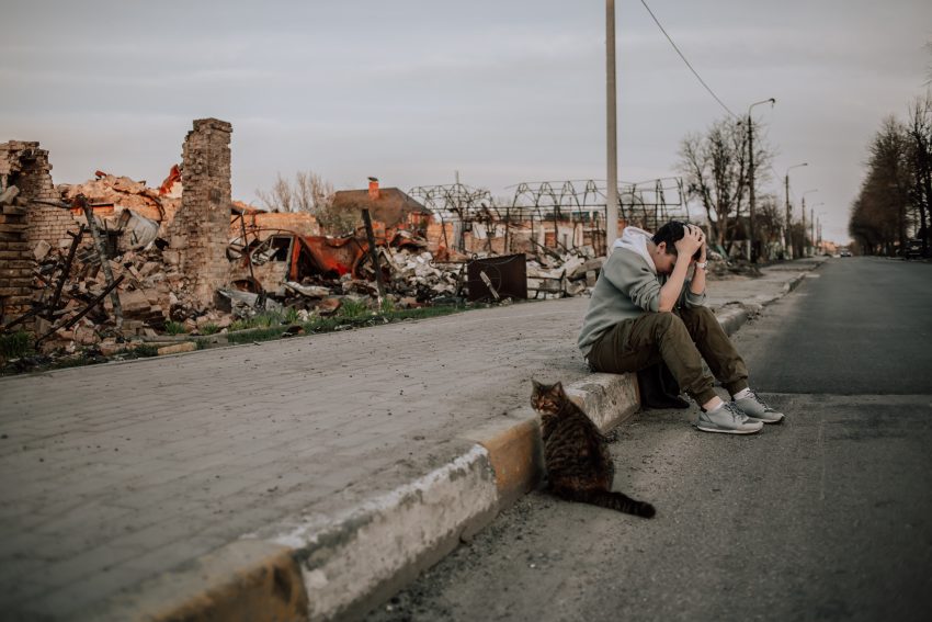 Copil care sta cu mainile la cap pe o strada distrusa din Bucha