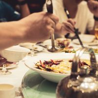 Oameni care mananca la masa unui restaurant din Beijing